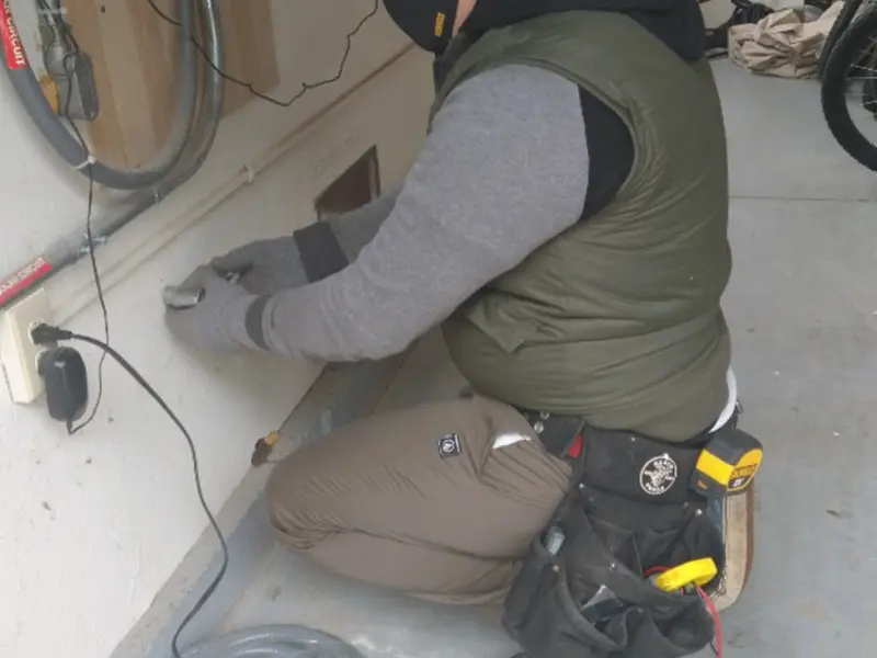 Electrician performing outlet wiring in a Blue Ridge garage